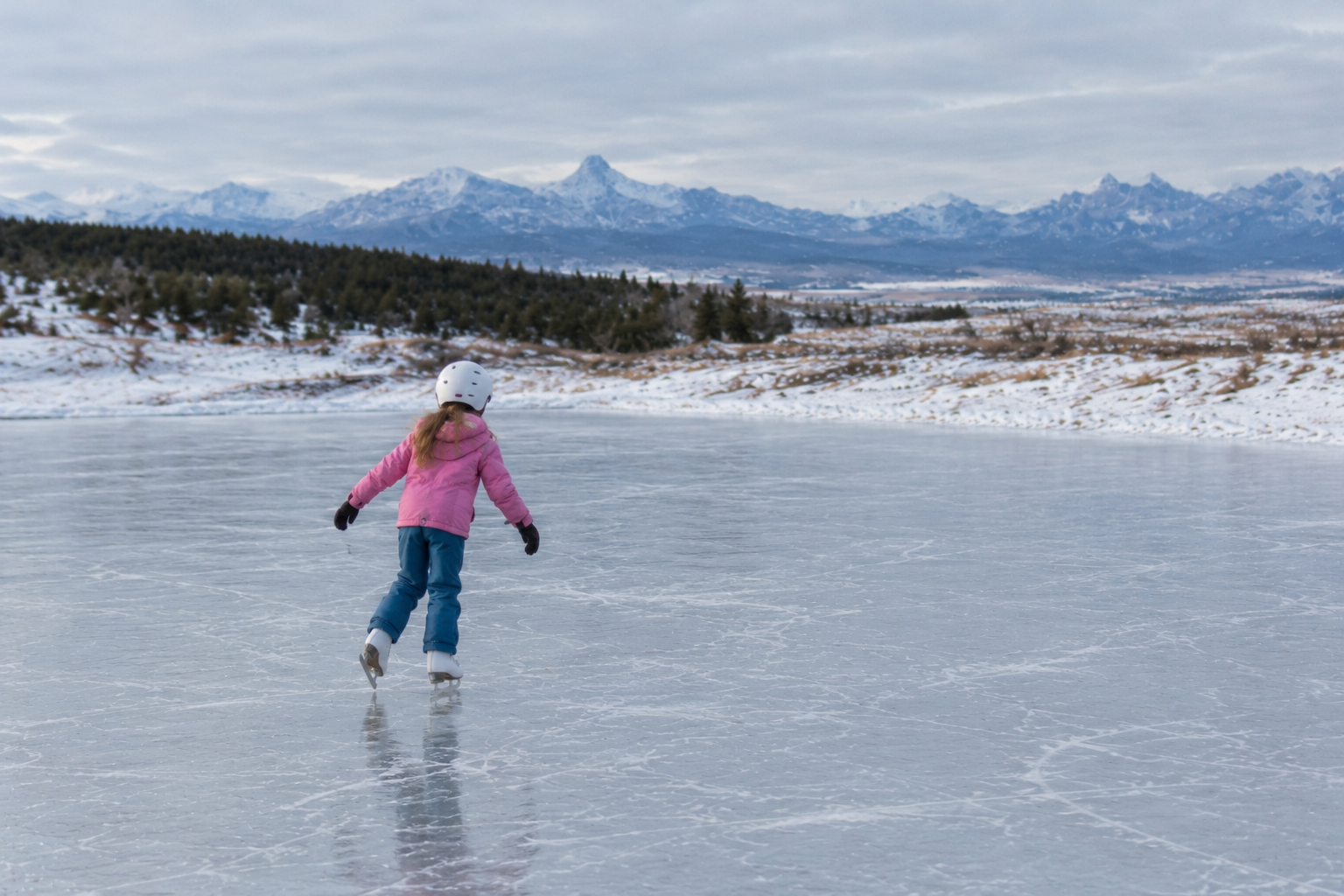 Skaters moving toward snowy mountain peaks